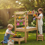 Two children playing with a wooden outdoor play table in a garden.