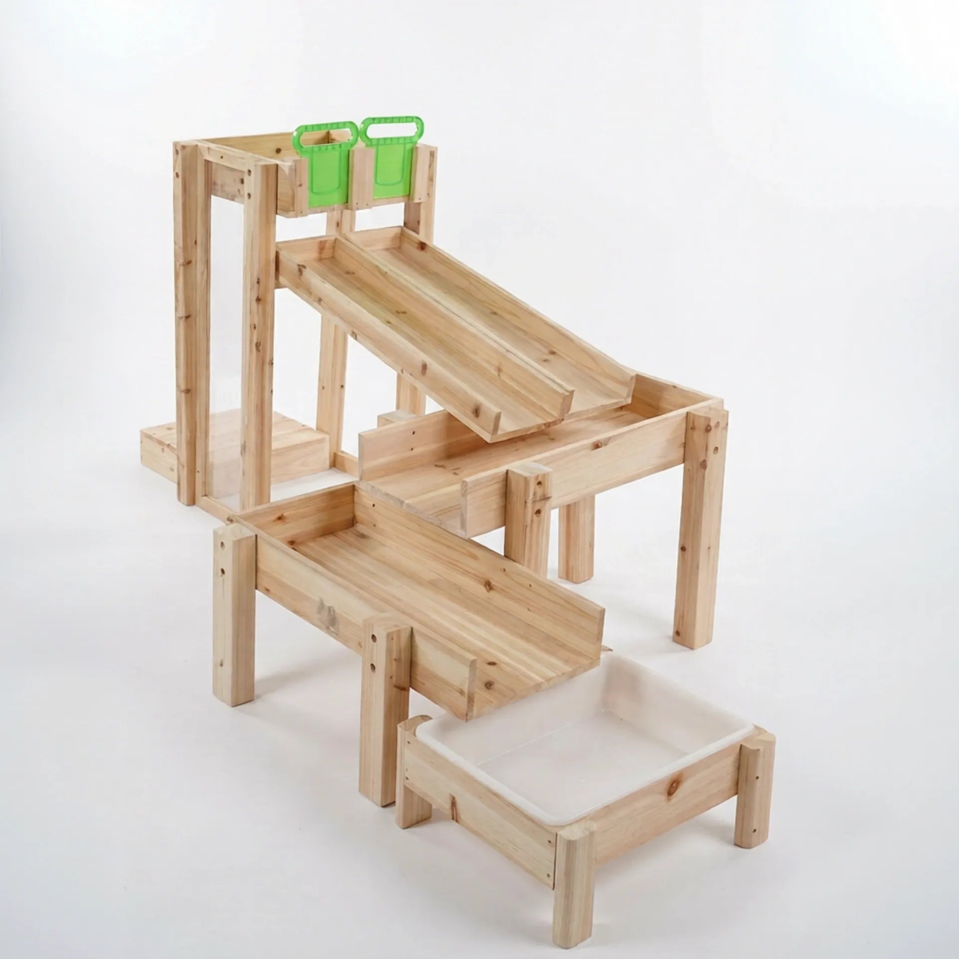 Wooden play structure with multiple levels and green toy bins on a white background