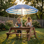 Child playing with a wooden water table in a garden
